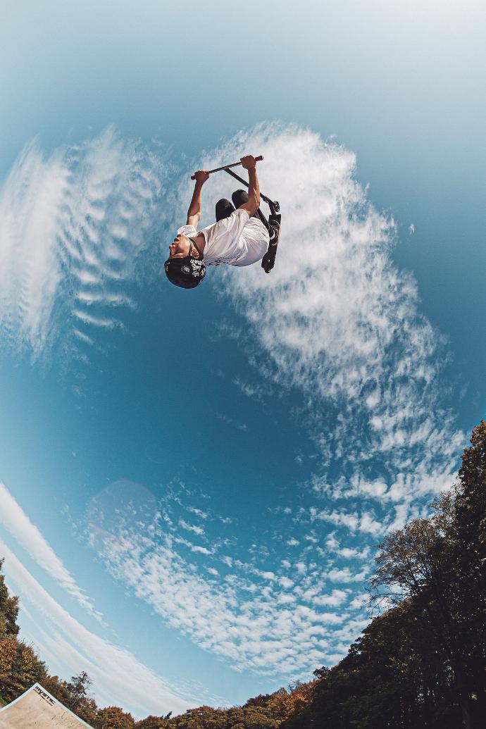 man back jumping near trees during daytime